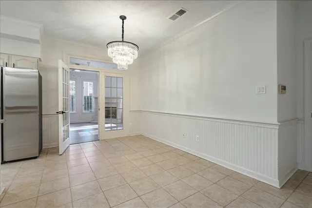a view of a refrigerator in kitchen and white cabinets