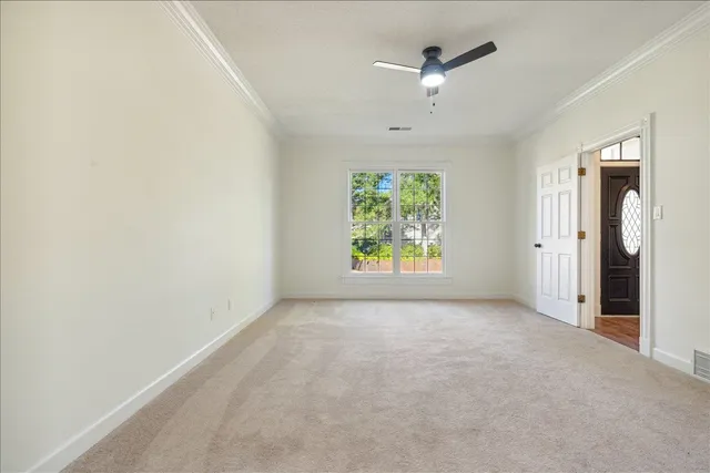 an empty room with window and ceiling fan