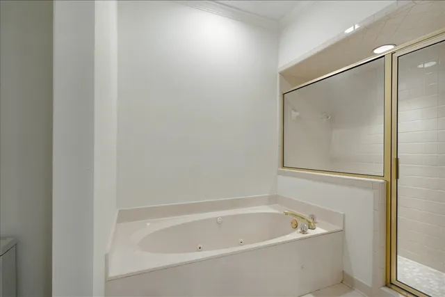 a white bath tub sitting next to a white sink and vanity