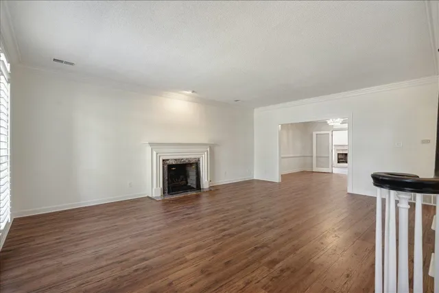 a view of empty room with wooden floor and fireplace