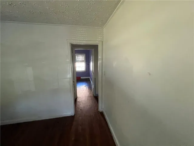 a view of a room with wooden floor and a window