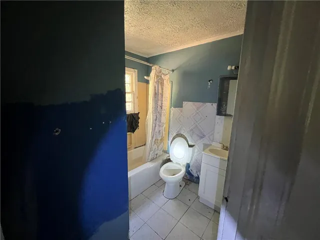 a bathroom with a granite countertop toilet and a sink