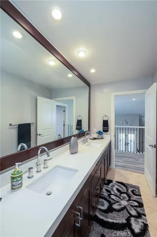 a bathroom with a sink double vanity granite tub shower and a mirror