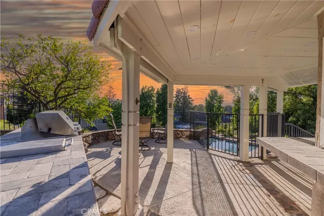 a balcony with table and chairs and potted plants