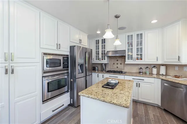 a kitchen with a sink stainless steel appliances and white cabinets