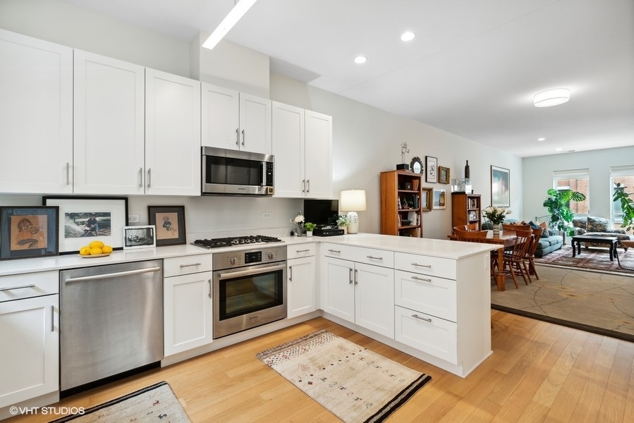1648 South Prairie Avenue, Unit 2 Chicago, IL 60616 - Photo 6 of 19 a kitchen with stainless steel appliances white cabinets sink and wooden floor