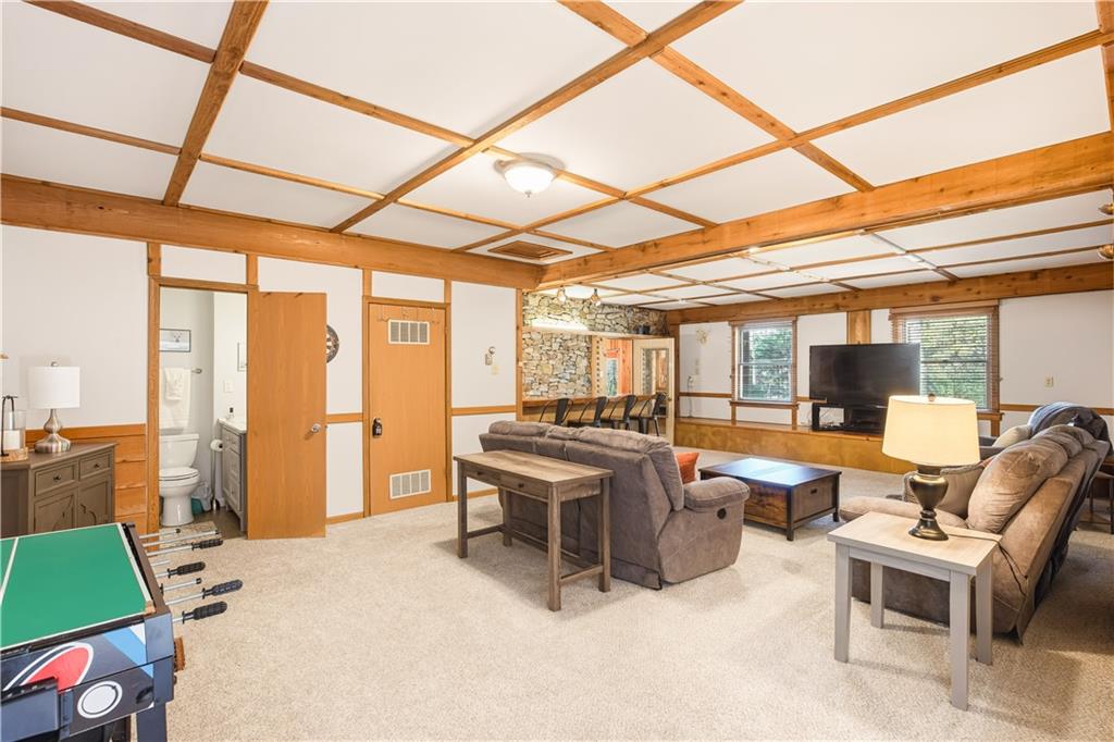 186 Lake Rd Lane Rockwood, PA 15557 - Photo 21 of 50 a living room with furniture a flat screen tv and floor to ceiling windows
