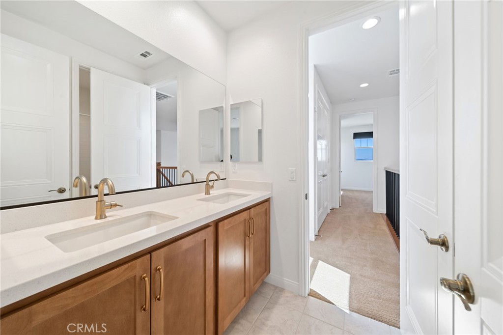 39565 Caladium Drive Temecula, CA 92591 - Photo 38 of 66 a bathroom with a double vanity sink and a mirror