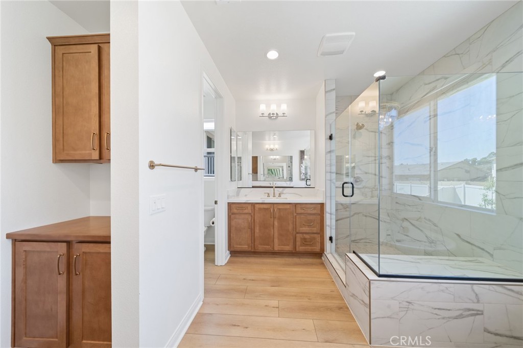 39565 Caladium Drive Temecula, CA 92591 - Photo 49 of 66 a bathroom with a glass shower door and a sink