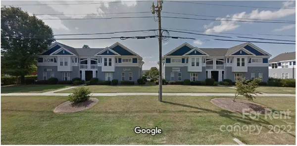 a view of a big house with a big yard and large tree