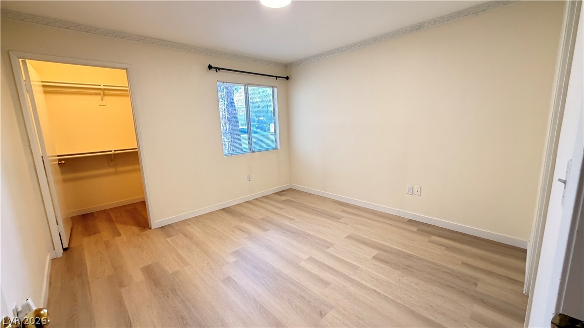 7885 West Flamingo Road, Unit 1131 Las Vegas, NV 89147 - Photo 24 of 36 A quiet bedroom featuring elegant crown molding and wood flooring.