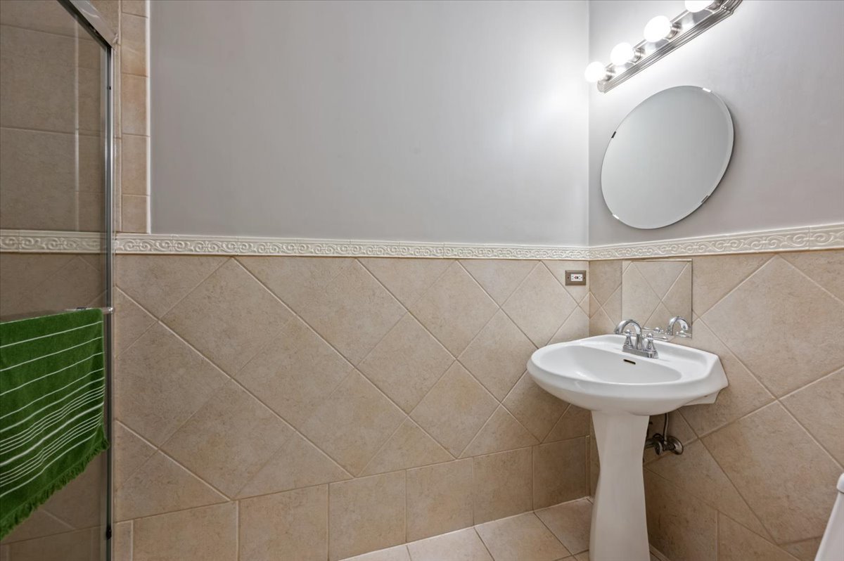 428 North Noble Street, Unit 2 Chicago, IL 60642 - Photo 11 of 20 a bathroom with a sink a mirror and a shower