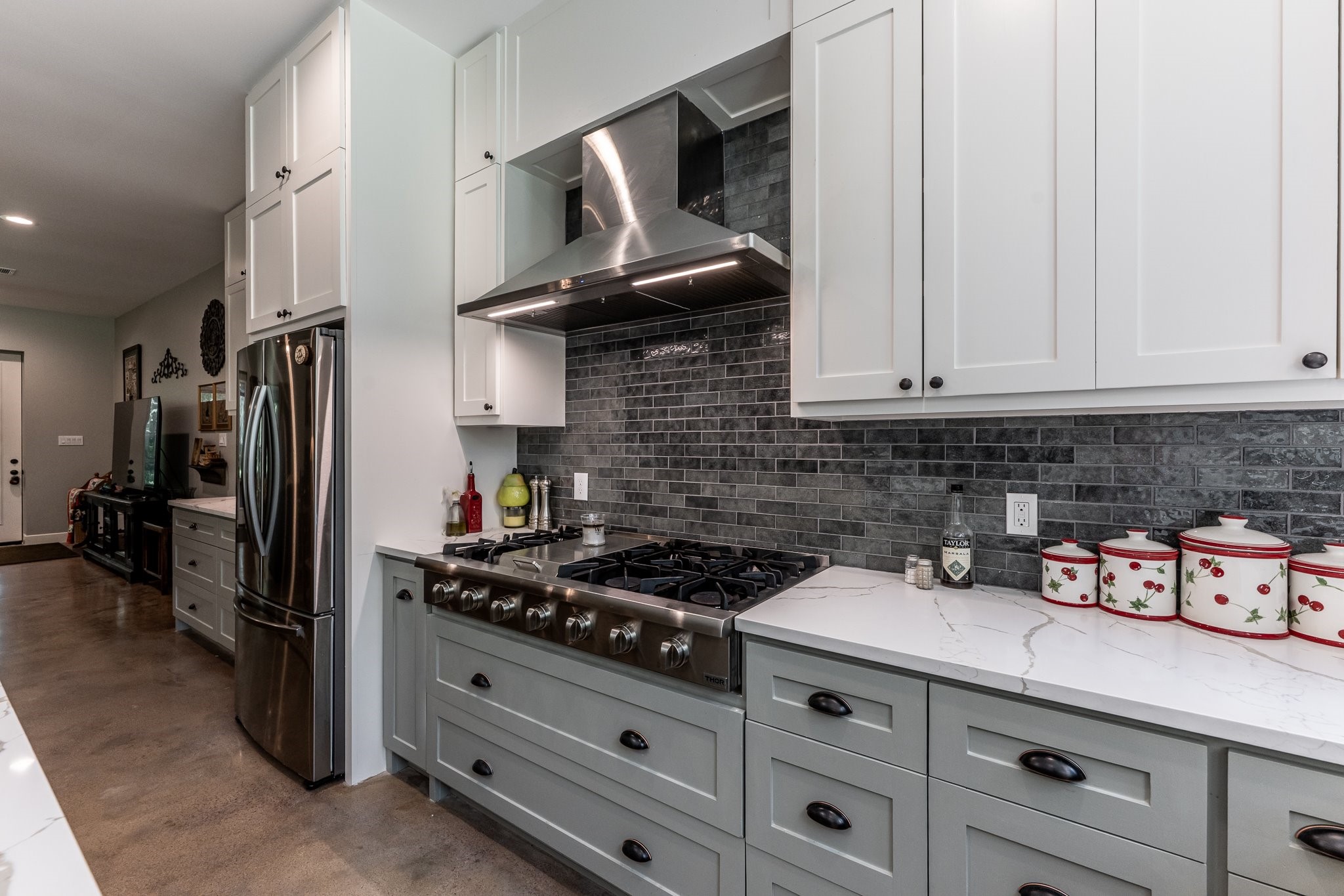 13334 Fultz Road Conroe, TX 77304 - Photo 4 of 49 A high-end gas range, custom cabinetry, and gorgeous backsplash bring five-star function to this country-chic kitchen.