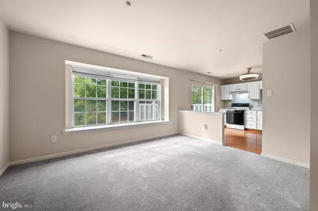 an empty room with a kitchen and windows