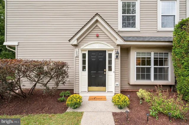 a front view of a house with a garden and potted plants