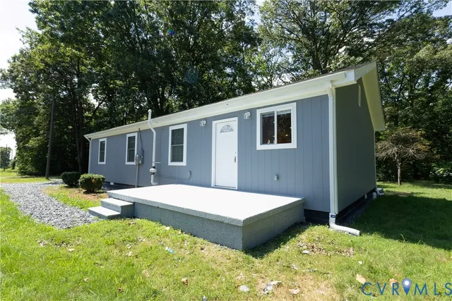 a backyard of a house with wooden fence and large trees