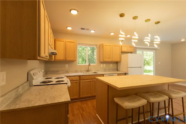 a kitchen with a sink a stove and chairs