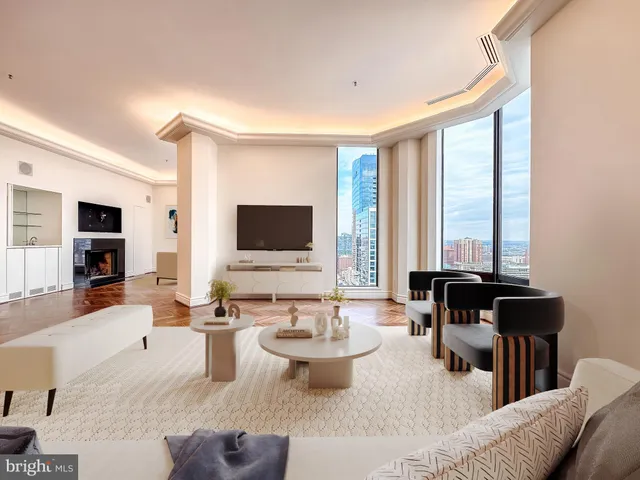 a living room with furniture flat screen tv and kitchen view