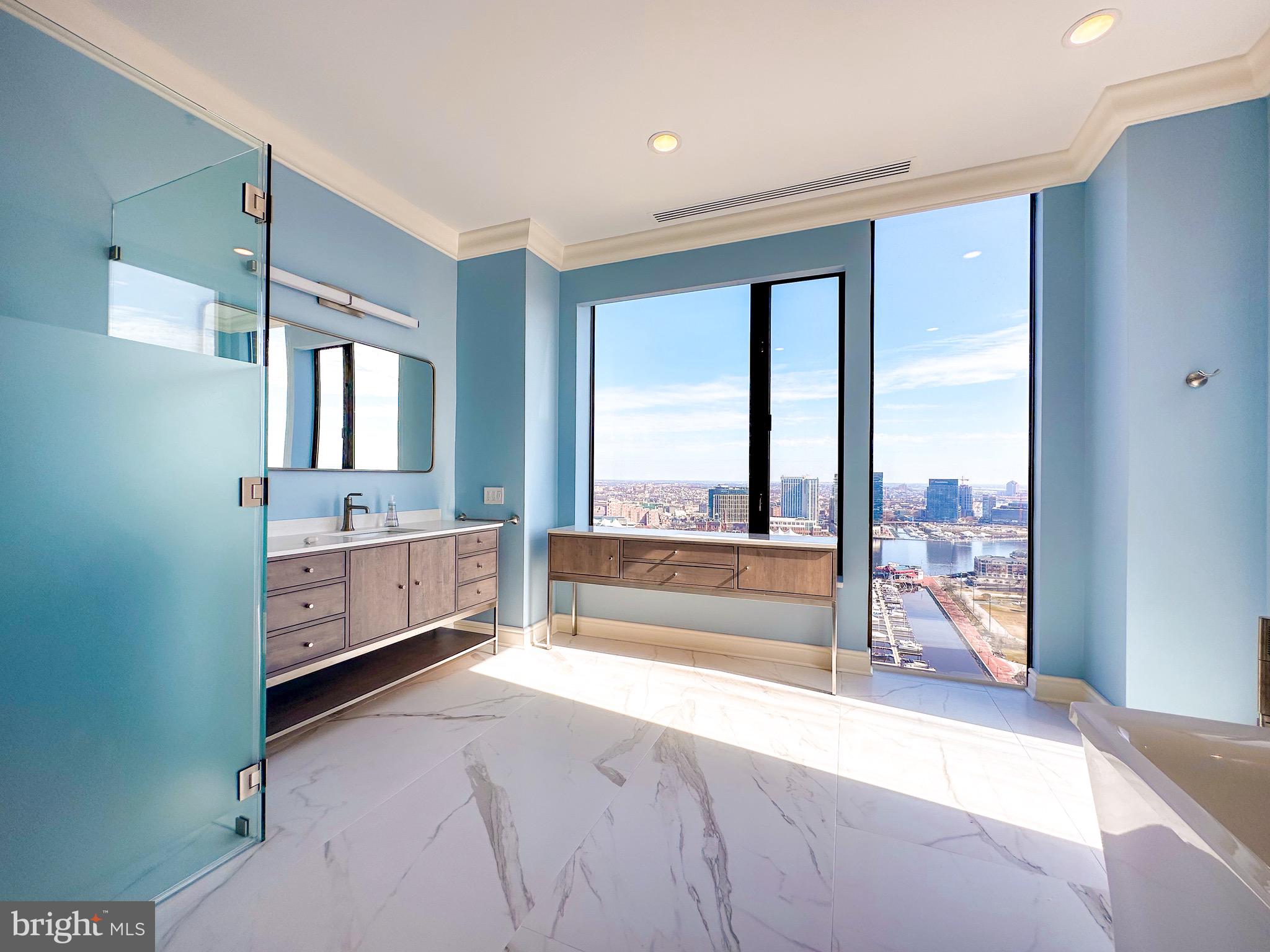 10 East Lee Street, Unit 2701 Baltimore, MD 21202 - Photo 37 of 58 a spacious bathroom with a large tub and mirror
