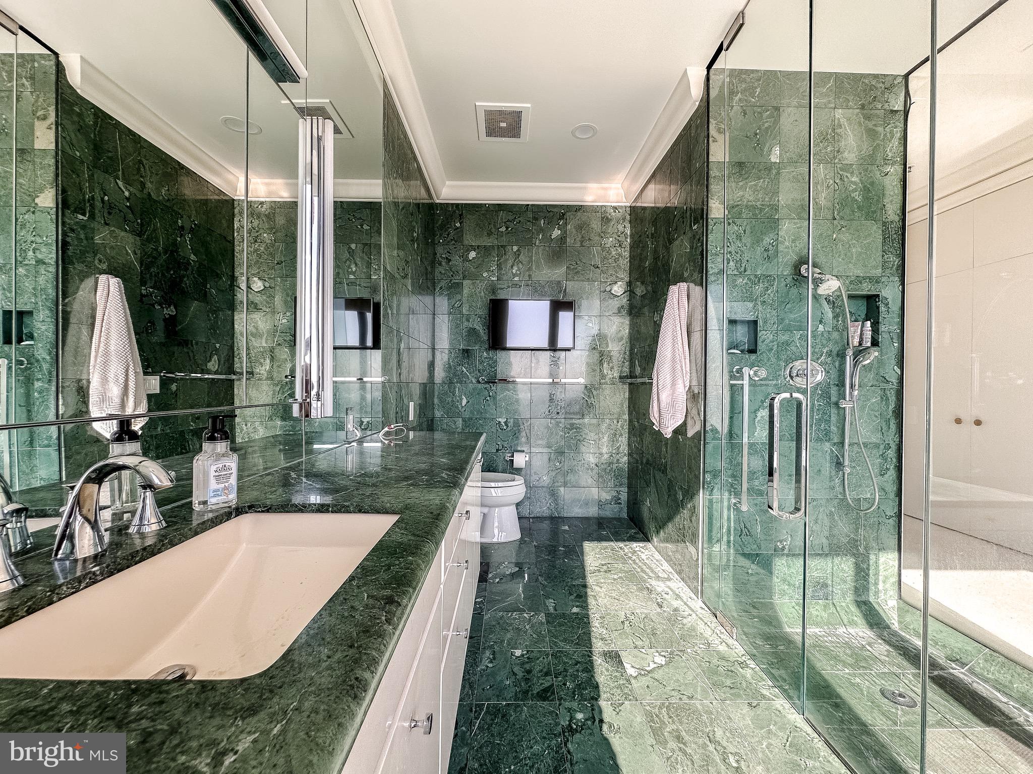 10 East Lee Street, Unit 2701 Baltimore, MD 21202 - Photo 40 of 58 a bathroom with a granite countertop sink a toilet and shower