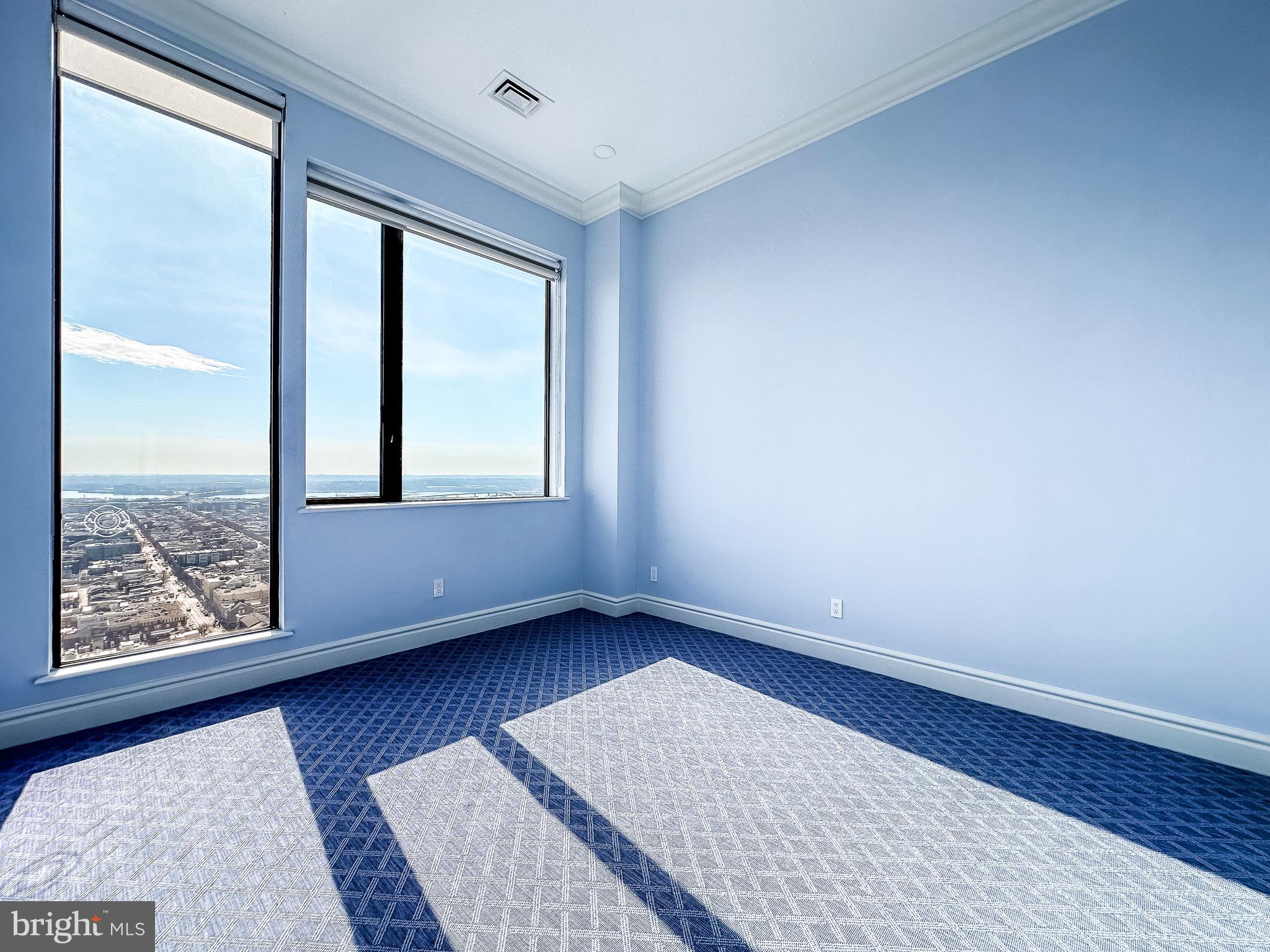 10 East Lee Street, Unit 2701 Baltimore, MD 21202 - Photo 46 of 58 an empty room with wooden floor and windows
