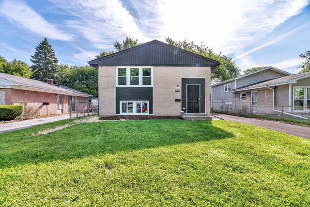 a front view of a house with yard and green space
