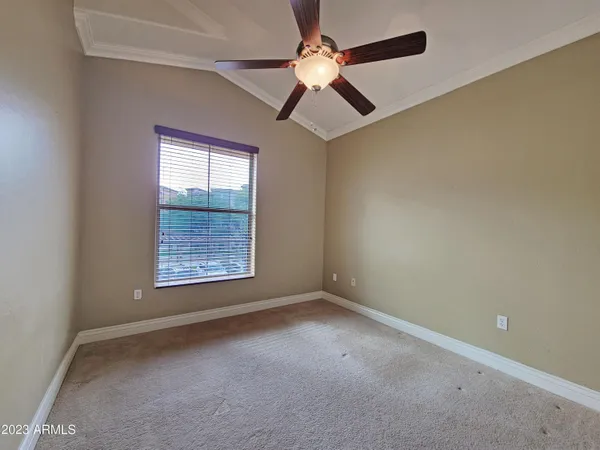 an empty room with a window and a fan