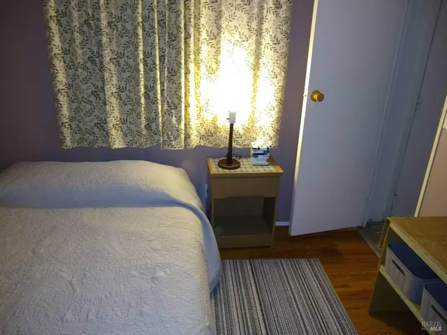 a room with wooden floor and potted plant