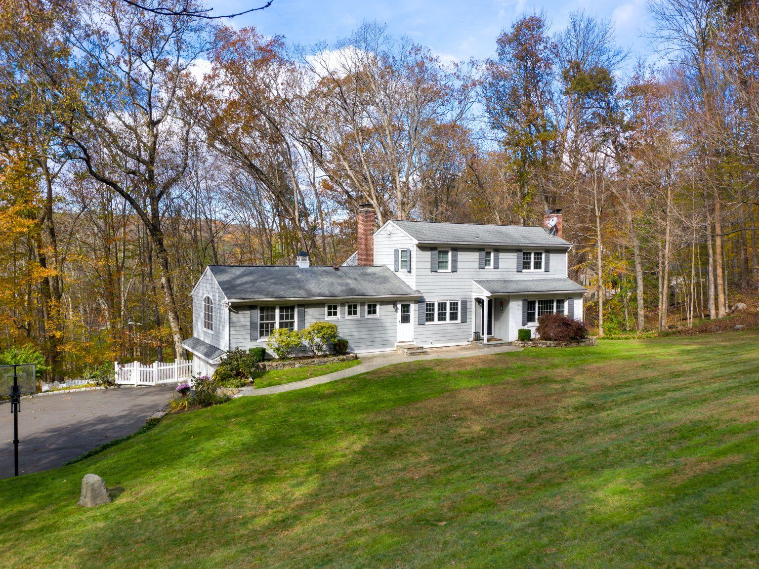 32 Colonial Road New Canaan, CT 06840 - Photo 1 of 22 a view of a house with a big yard and large trees