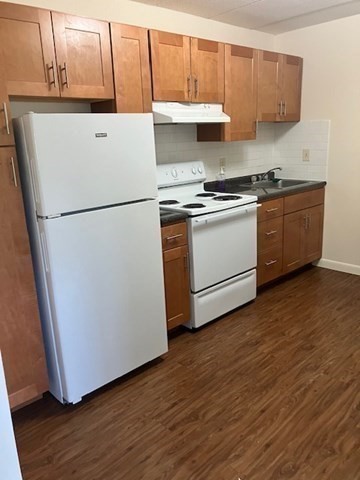 763 Main Street, Unit 44 Waltham, MA 02451 - Photo 5 of 11 a white refrigerator freezer sitting inside of a kitchen with stainless steel appliances wooden floor