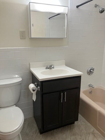 763 Main Street, Unit 44 Waltham, MA 02451 - Photo 10 of 11 a bathroom with a toilet a sink and mirror