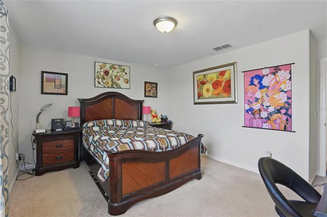 a bedroom with bed and paintings on the wall