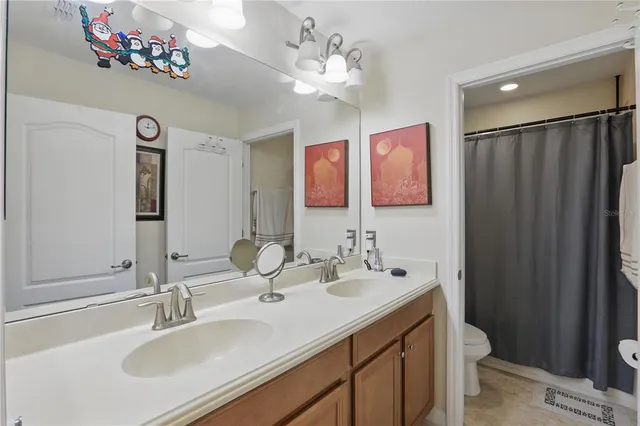 a bathroom with a double vanity sink mirror and toilet