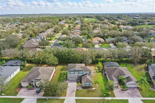 an aerial view of residential houses with outdoor space and parking