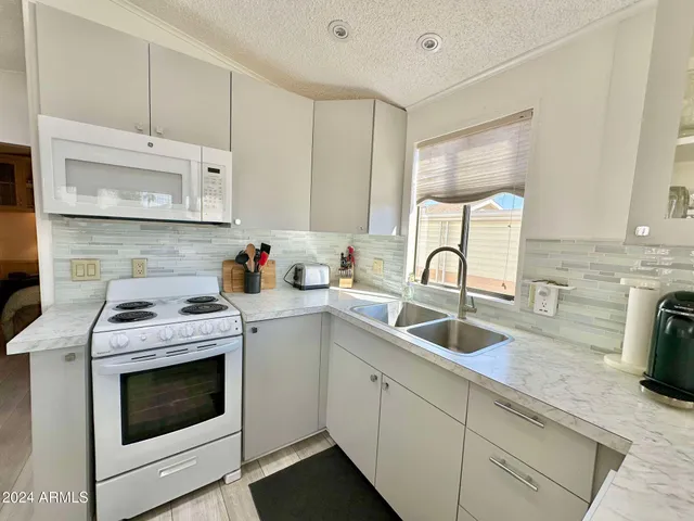 a kitchen with sink a window and cabinets
