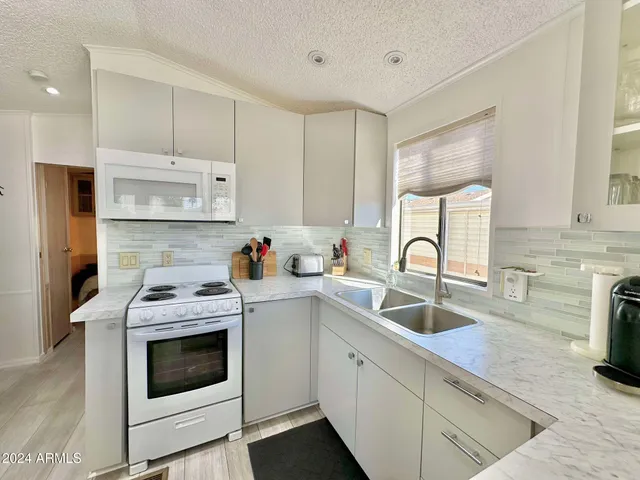 a kitchen with granite countertop a sink stainless steel appliances and cabinets