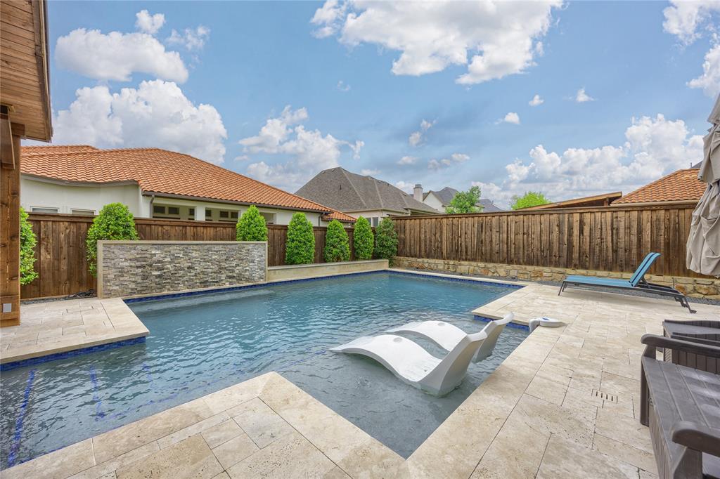 918 Sydney Lane Allen, TX 75013 - Photo 36 of 40 The property features a swimming pool with an integrated water feature, surrounded by a paved patio area