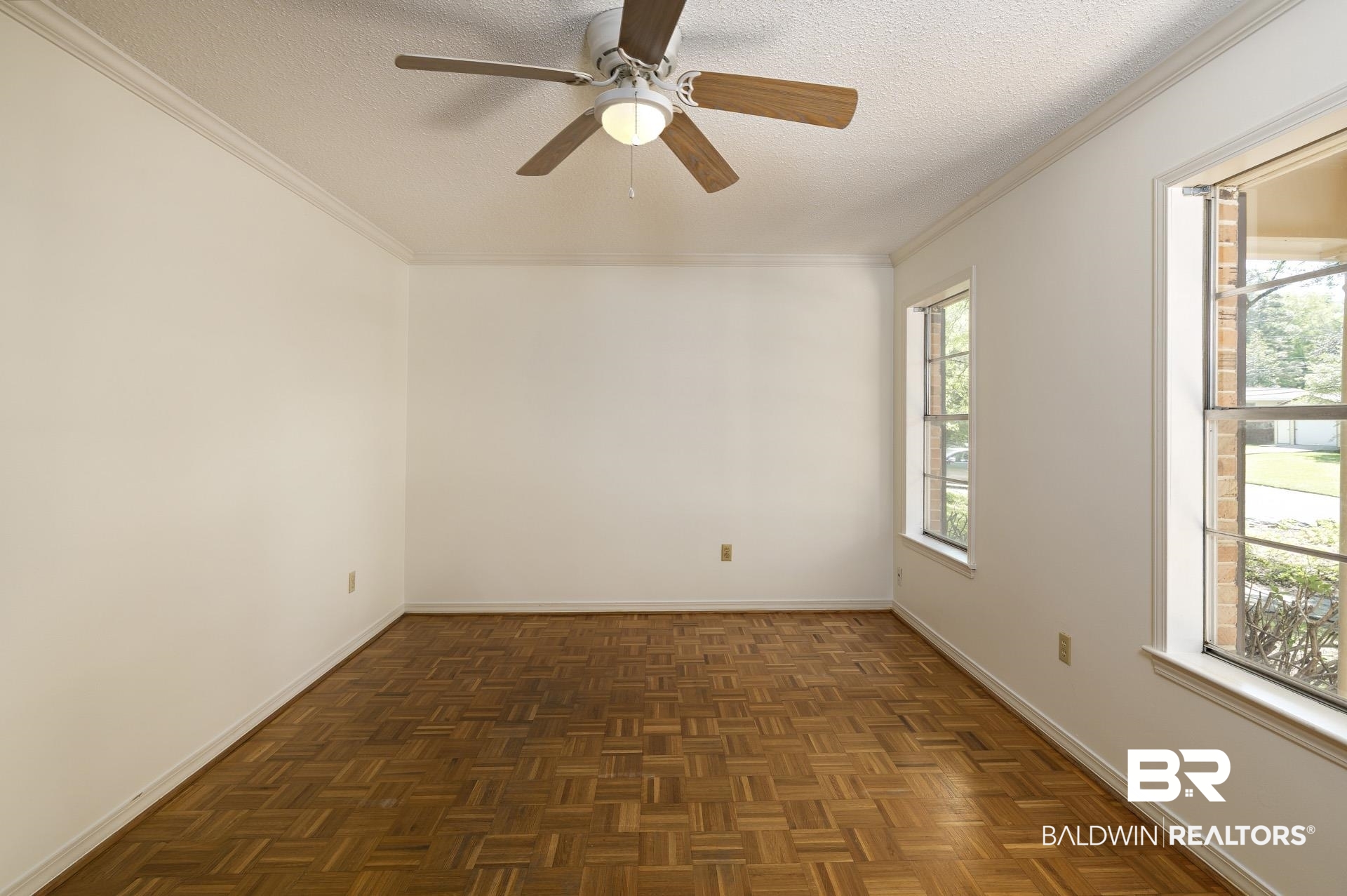 707 Johnson Avenue Fairhope, AL 36532 - Photo 14 of 38 Empty room featuring a textured ceiling, ornamental molding, and a wealth of natural light