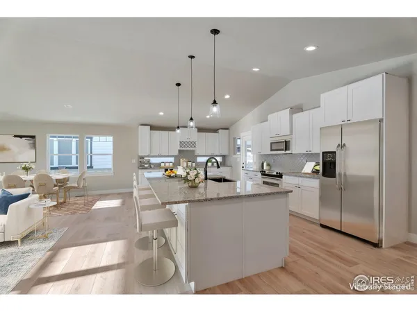 a kitchen with stainless steel appliances kitchen island granite countertop a sink and a refrigerator