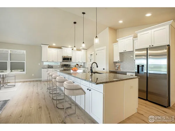 a kitchen with stainless steel appliances granite countertop a sink refrigerator and cabinets