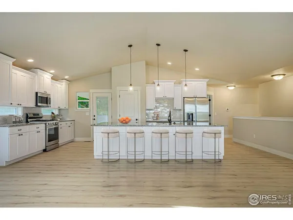 a kitchen with stainless steel appliances kitchen island granite countertop a stove a sink and a refrigerator