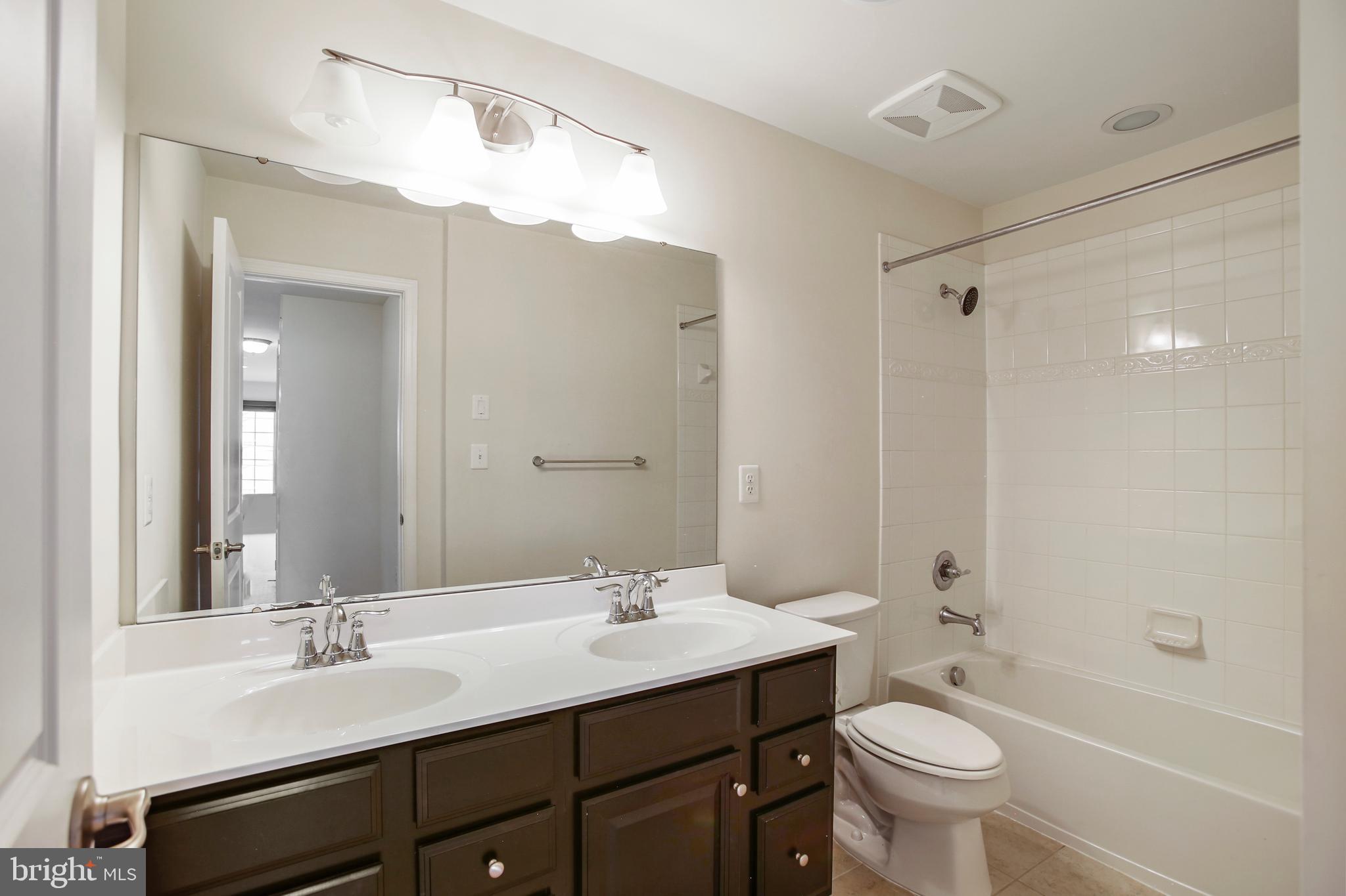 41597 Hoffman Drive Aldie, VA 20105 - Photo 33 of 42 a bathroom with a sink double vanity granite tub and a mirror
