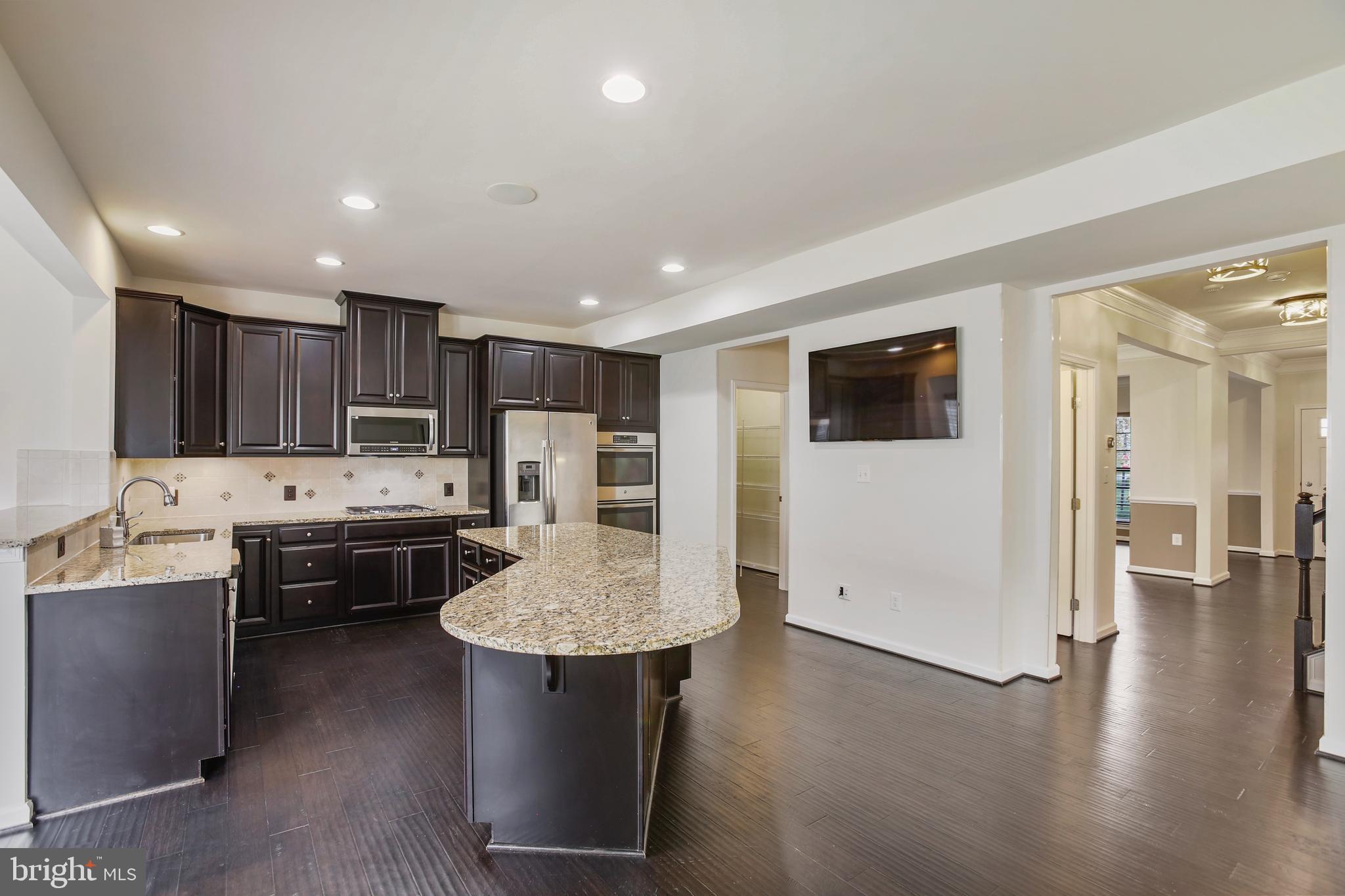 41597 Hoffman Drive Aldie, VA 20105 - Photo 8 of 42 a kitchen with stainless steel appliances kitchen island granite countertop a refrigerator a stove a sink a oven with white cabinets and wooden floor