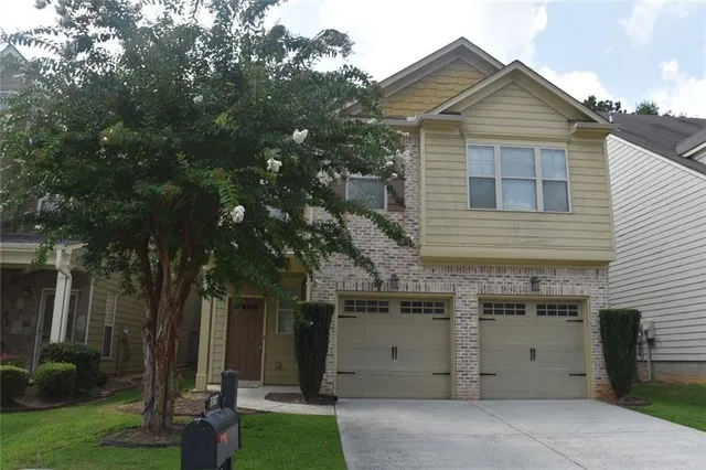 a view of a house with a yard and tree s