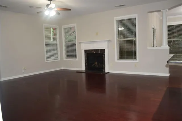 a view of a livingroom with a fireplace wooden floor and windows