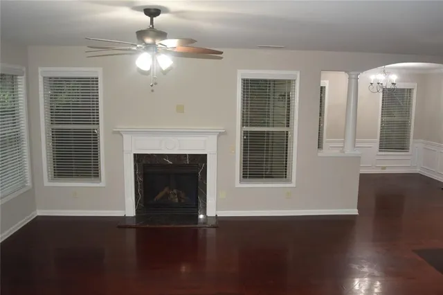 a view of an empty room with wooden floor and a fireplace