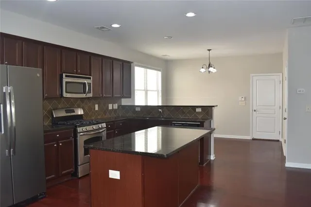 a kitchen with granite countertop a stove and a refrigerator