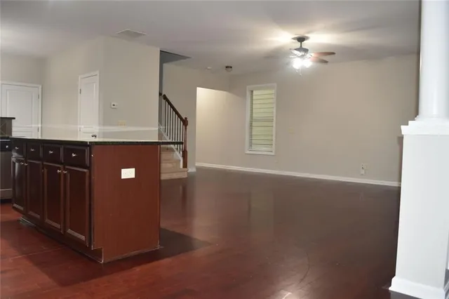 a view of an empty room with window and wooden floor