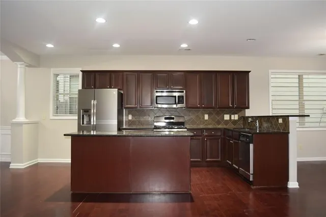 a living room with a stove and a refrigerator
