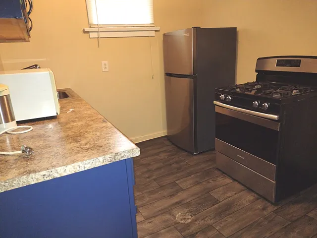 a kitchen with a refrigerator and a stove